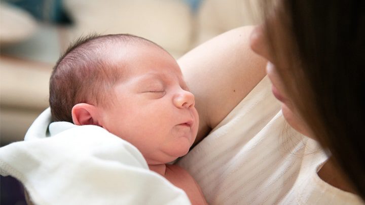 bébé qui dort dans les bras de sa mère | Photographie de nouveau-né